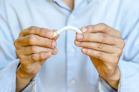 Male hand breaking the last cigarette to stop smokingの写真素材