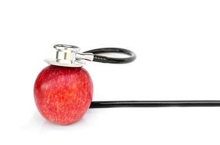 Red apple and Medical stethoscope isolated on white backgroundの写真素材