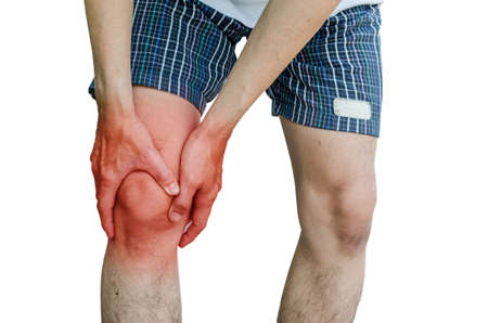 Acute pain in a man knee. male holding hand to spot of knee-aches. Isolation on a white background.の写真素材