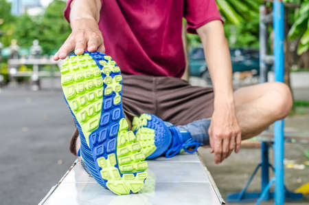 Young man stretching his legs outdoors in the park