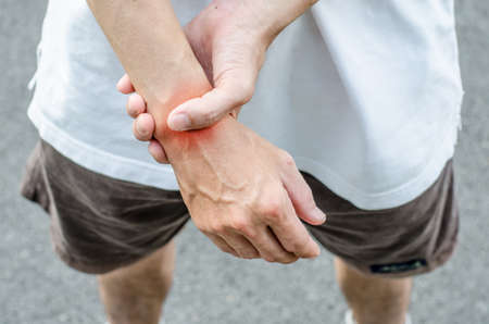 Wrist pain. Male holding hand to spot of wrist pain.の写真素材