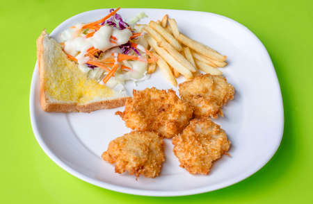 Fish Steaks, french fries with vegetables salad on a plateの写真素材