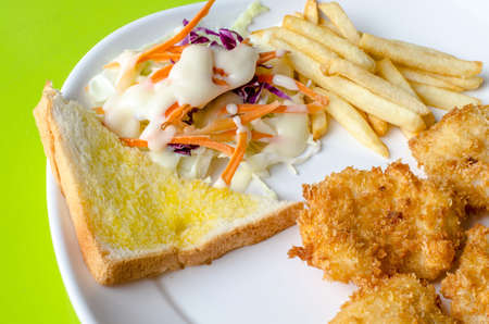 Fish Steaks, french fries with vegetables salad on a plateの写真素材