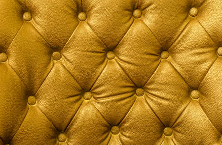 Texture of gold leather vintage sofa for backgroundの写真素材