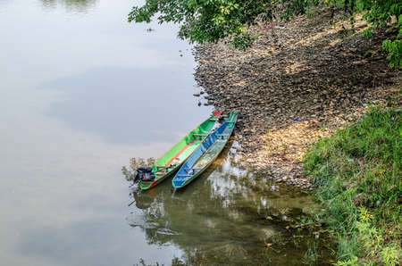 Two small open plastic boats moored at riverの写真素材