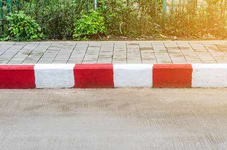 Red and White sign on the sidewalk backgroundの写真素材