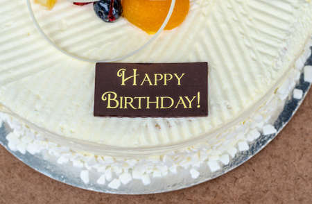 vanilla cake with words happy birthday on itの写真素材