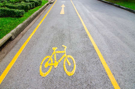 yellow arrows and bicycle sign path on the roadの写真素材