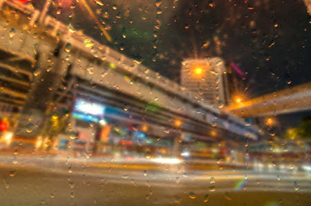 Rain water drops on a window glass after the rain with cityscape and street view on backgroundの写真素材
