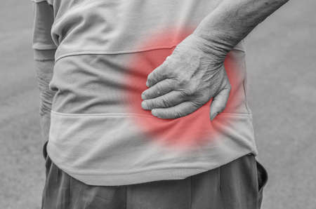 Senior man with back pain, isolated in whiteの写真素材