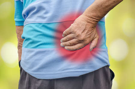 Senior man with back pain, isolated in whiteの写真素材