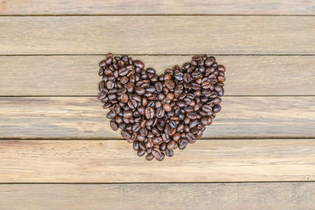 Heart from coffee beans on wooden backgroundの写真素材