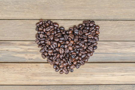 Heart from coffee beans on wooden backgroundの写真素材