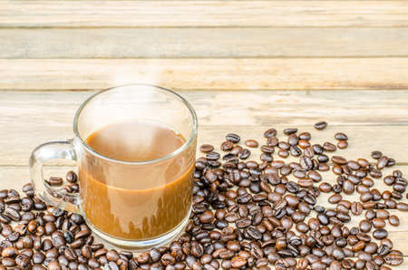 Fresh coffee and coffee beans on wood backgroundの写真素材
