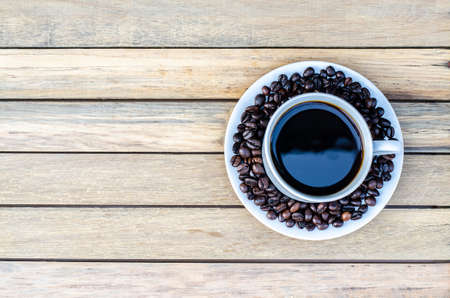 Coffee cup with coffee bean on wooden table view from topの写真素材