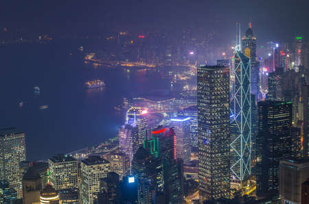 Hong Kong the scenes, victoria harbour from the peak bird view, in the mist with bad weather in the night, nimbus landscape on the trailsの写真素材