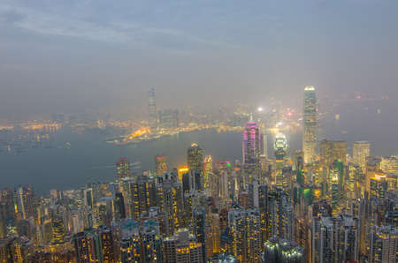 Hong Kong the scenes, victoria harbour from the peak bird view, in the mist with bad weather in the night, nimbus landscape on the trailsの写真素材