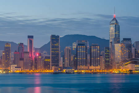 Hong Kong city office building over Victoria bay during sunriseの写真素材