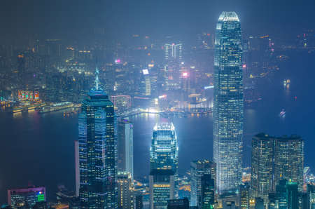 Hong Kong the scenes, victoria harbour from the peak bird view, in the mist with bad weather in the night, nimbus landscape on the trailsの写真素材