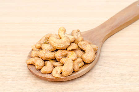 cashew nuts with salt on wood tableの写真素材