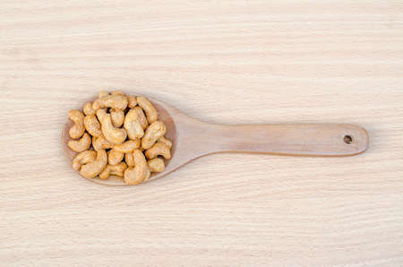 cashew nuts with salt on wood tableの写真素材