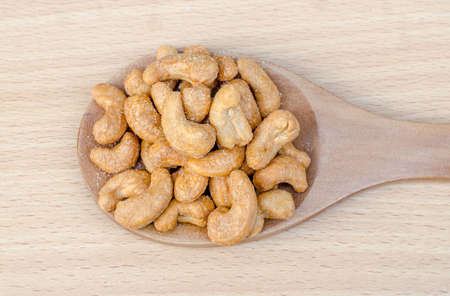 cashew nuts with salt on wood tableの写真素材