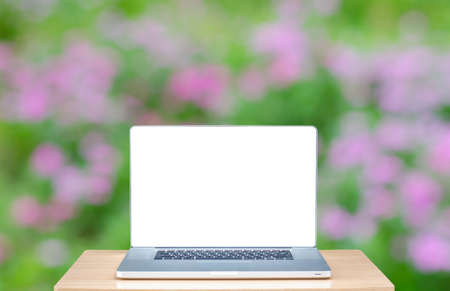 laptop computer with blank screen over wooden table indoor and blurred background