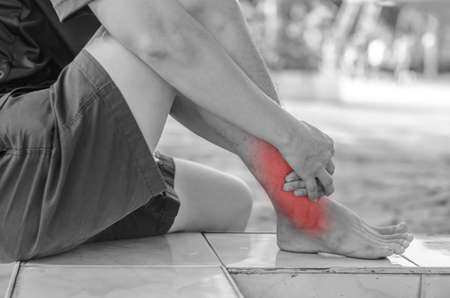 Asian men health care.he is holding her ankle in pain at basketball court
