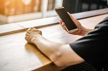 young man working from coffee shop using smart phoneの写真素材
