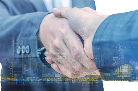 Closeup of two businessmen shaking hands against white backgroundの写真素材