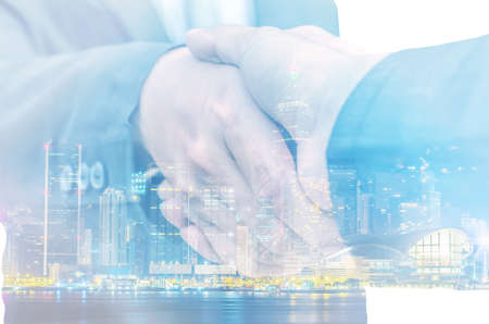 Closeup of two businessmen shaking hands against white backgroundの写真素材