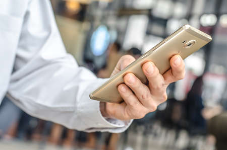young man working from coffee shop using smart phone , man's hands using smart phone in interior.の写真素材