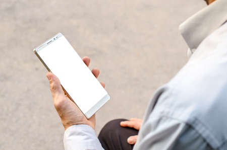 Man uses his Mobile Phone is outdoor park, close up