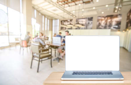 laptop computer with blank screen over wooden table indoor and blurred backgroundの写真素材