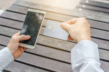 Online payment,Man's hands holding a credit card and using smart phone for online shopping