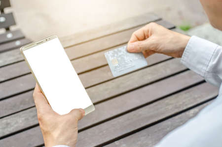 Online payment,Man's hands holding a credit card and using smart phone for online shopping