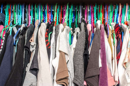 Fashion clothes on clothing rack - bright colorful closet. Close up of rainbow color choice of trendy female wear on hangers in store closet . Summer home wardrobe.の写真素材