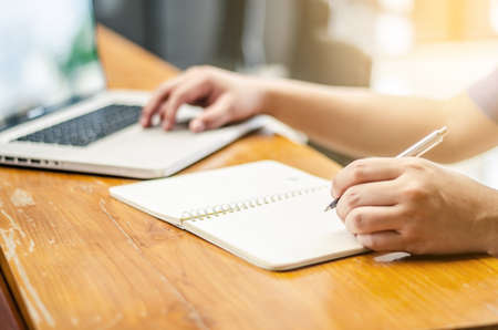Man Working Laptop Technology and Writing Notebook Workplace Conceptの写真素材