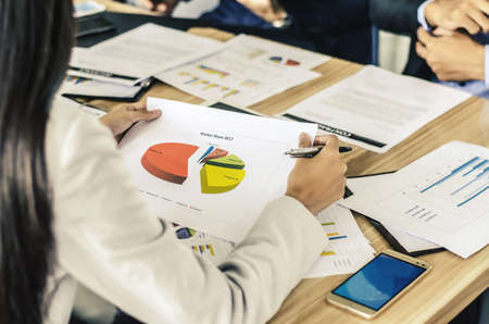 Businesspeople discussing analyzing financial figures  together in conference room during meeting at officeの写真素材