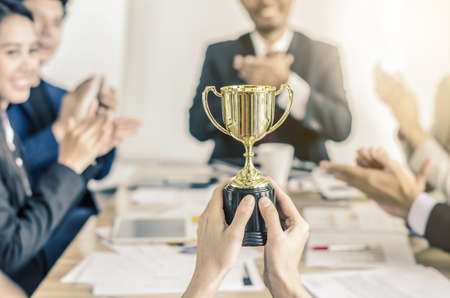 winning business team gold trophy , business team happy consent and successful business team rewarded for in the officeの写真素材