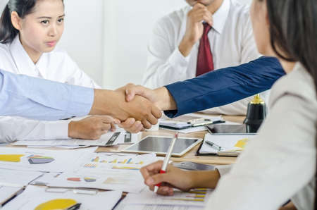 Businessman shaking hands to seal a deal with his partner and colleagues after finishing up meetingin a modern officeの写真素材