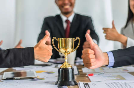 winning business team gold trophy , business team happy consent and successful business team rewarded for in the officeの写真素材