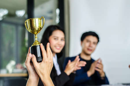 winning business team gold trophy , business team happy consent and successful business team rewarded for in the officeの写真素材