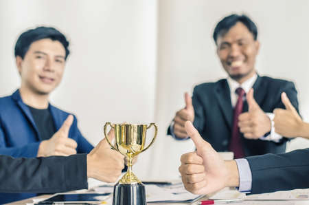 winning business team gold trophy , business team happy consent and successful business team rewarded for in the officeの写真素材