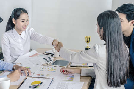 Nice to meet you Close-up of two businesswomen shaking hands with smile while sitting at the...
