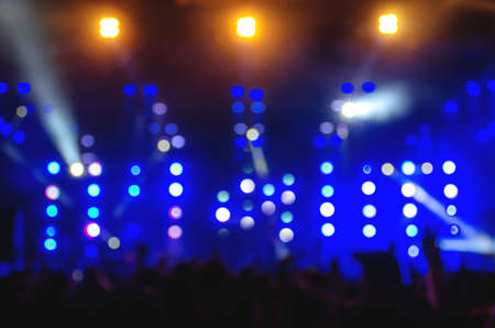 Background image with blurs and lights : Bokeh lighting blurred concert crowd enjoying the music.