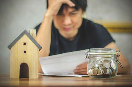 Young man checking bills and having financial problems with home debt, Money concept., real estate, buy an apartmentの写真素材