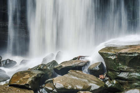 cold river waterfall cascade falling down on stones in national reserve park Thailand