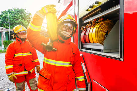 Portrait of a fire fighter carrying fire hose on shoulderのeditorial素材