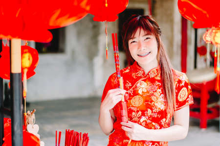 Portrait charming beautiful asian woman wear cheongsam dress up choose buy the incense, in the Chinese New Year. Festivities, New Year Celebrationの写真素材